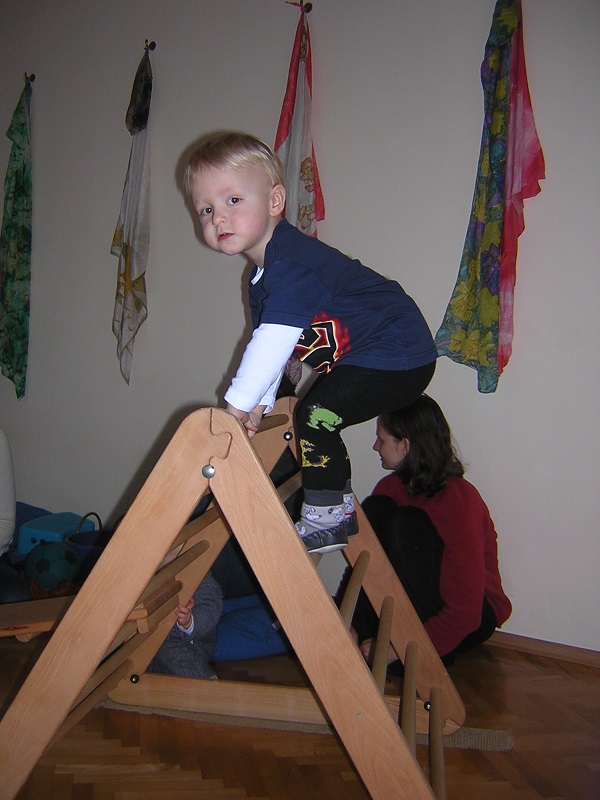 Kleinkind klettert auf einem Pikler-Dreieck