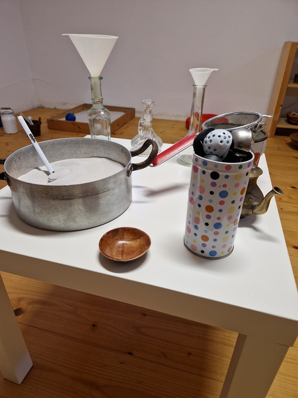 Offenes Spielmaterial aus Holz und Küchenutensilien im SandSpielRaum für Kleinkinder