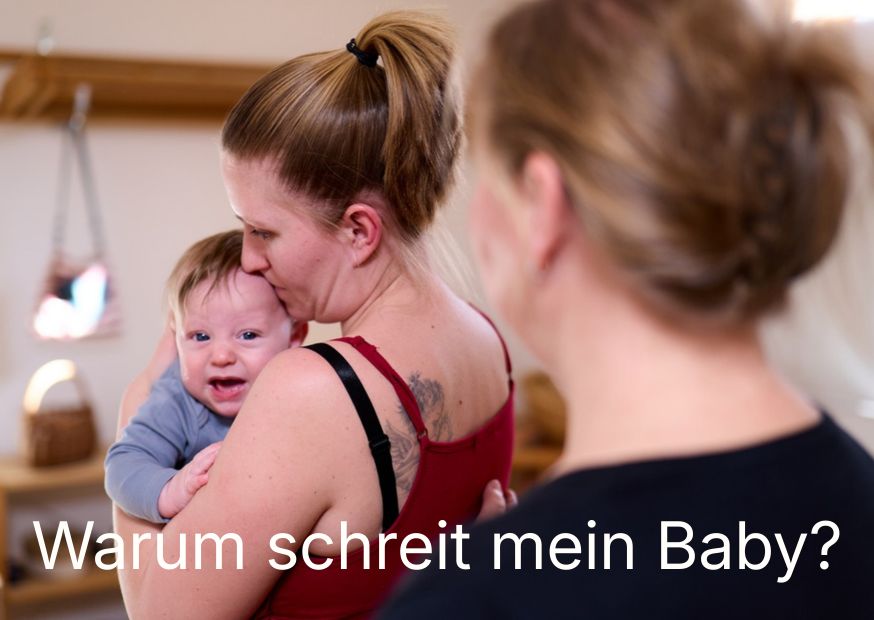 Mutter mit schreiendem Baby im Arm. Dahinter eine Frau, die unterstützt